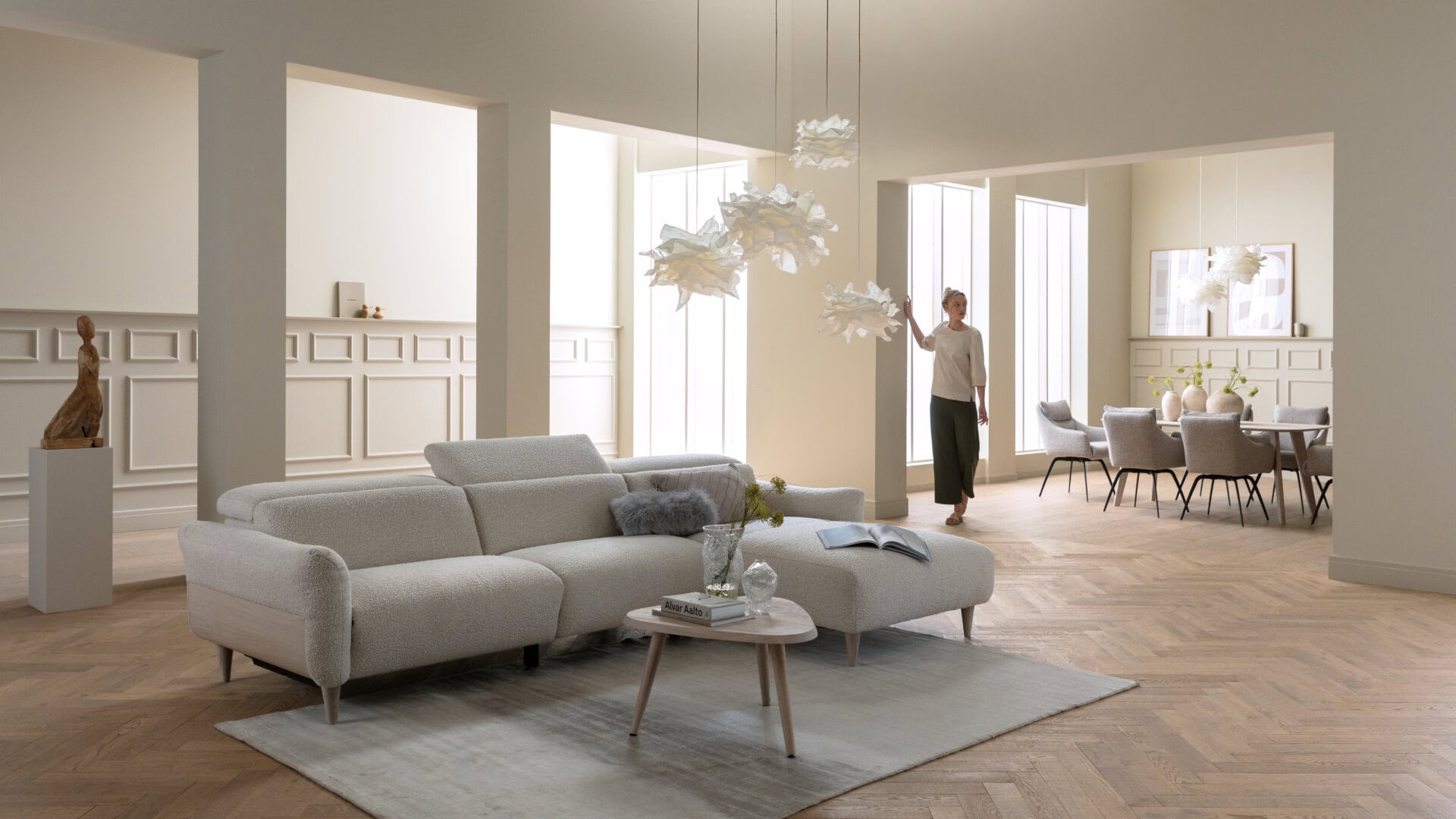 Skagen Studio Birkholm modular sofa in cream fabric, in a bright living room with a person standing beside it.