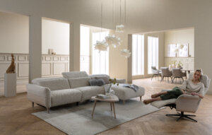 Skagen Studio Birkholm modular sofa in cream fabric, in a bright living room with two people on the sofa.