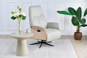 Skagen Studio Hejrede Essential recliner in Madras white leather with a light wood shell and black swivel base, in a styled living room.